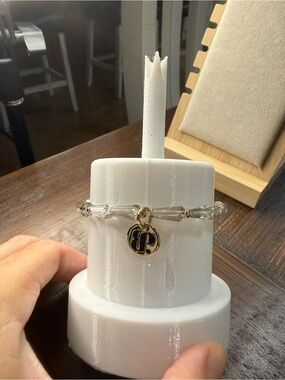 Bomb party stretch Gold-Accented Clear Bead Bracelet with Logo Charm